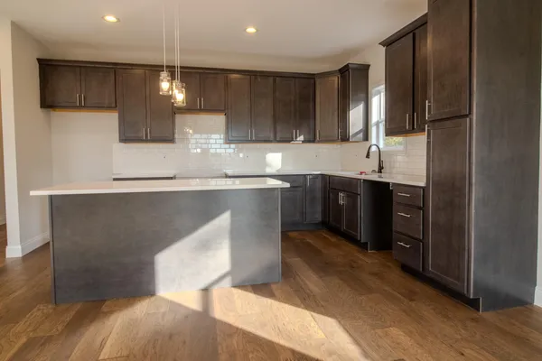 a kitchen with stainless steel appliances granite countertop a sink a stove and a refrigerator