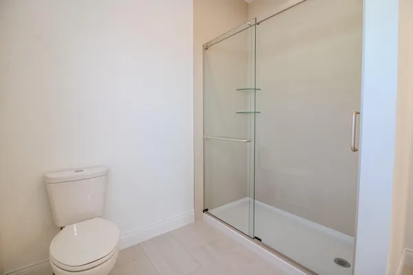 a white toilet next to a bathroom