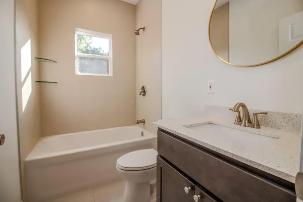 a bathroom with a granite countertop sink a toilet and bathtub