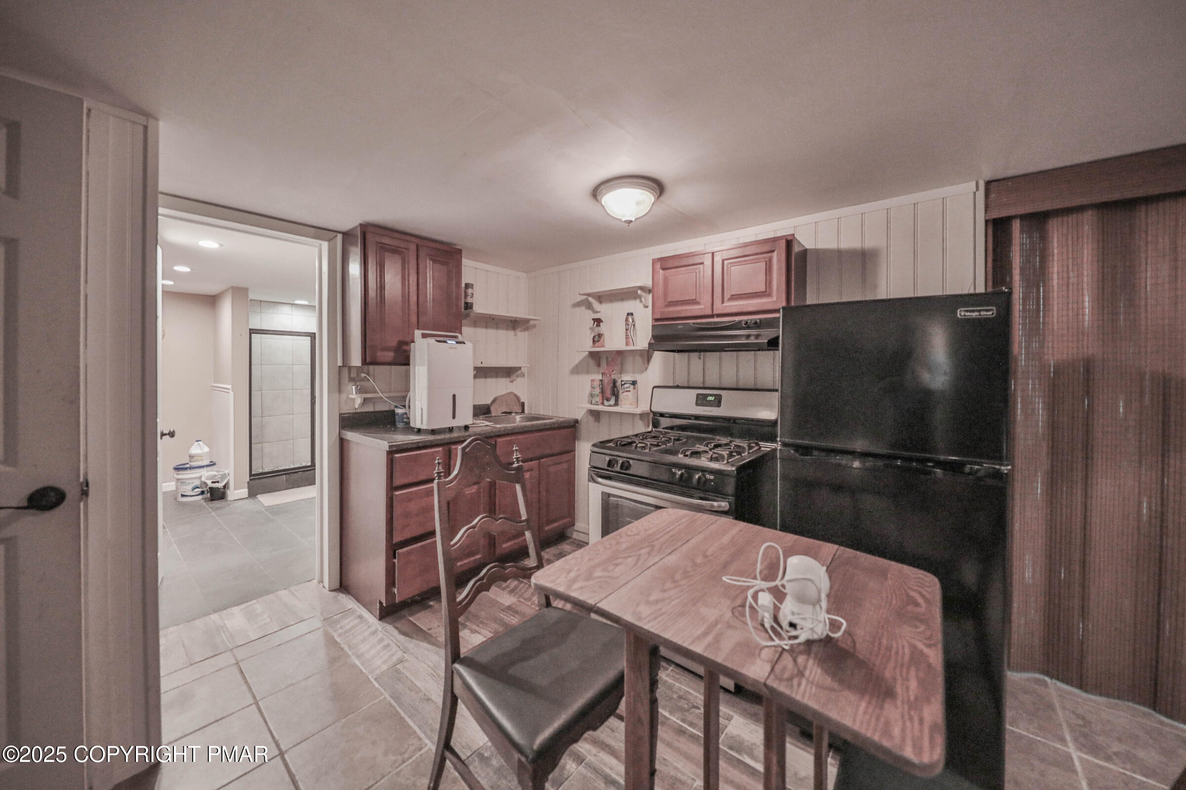 1094 Maple Lake Drive Bushkill, PA 18324 - Photo 52 of 81 a kitchen with stainless steel appliances granite countertop a refrigerator a stove a sink a dining table and chairs with wooden floor