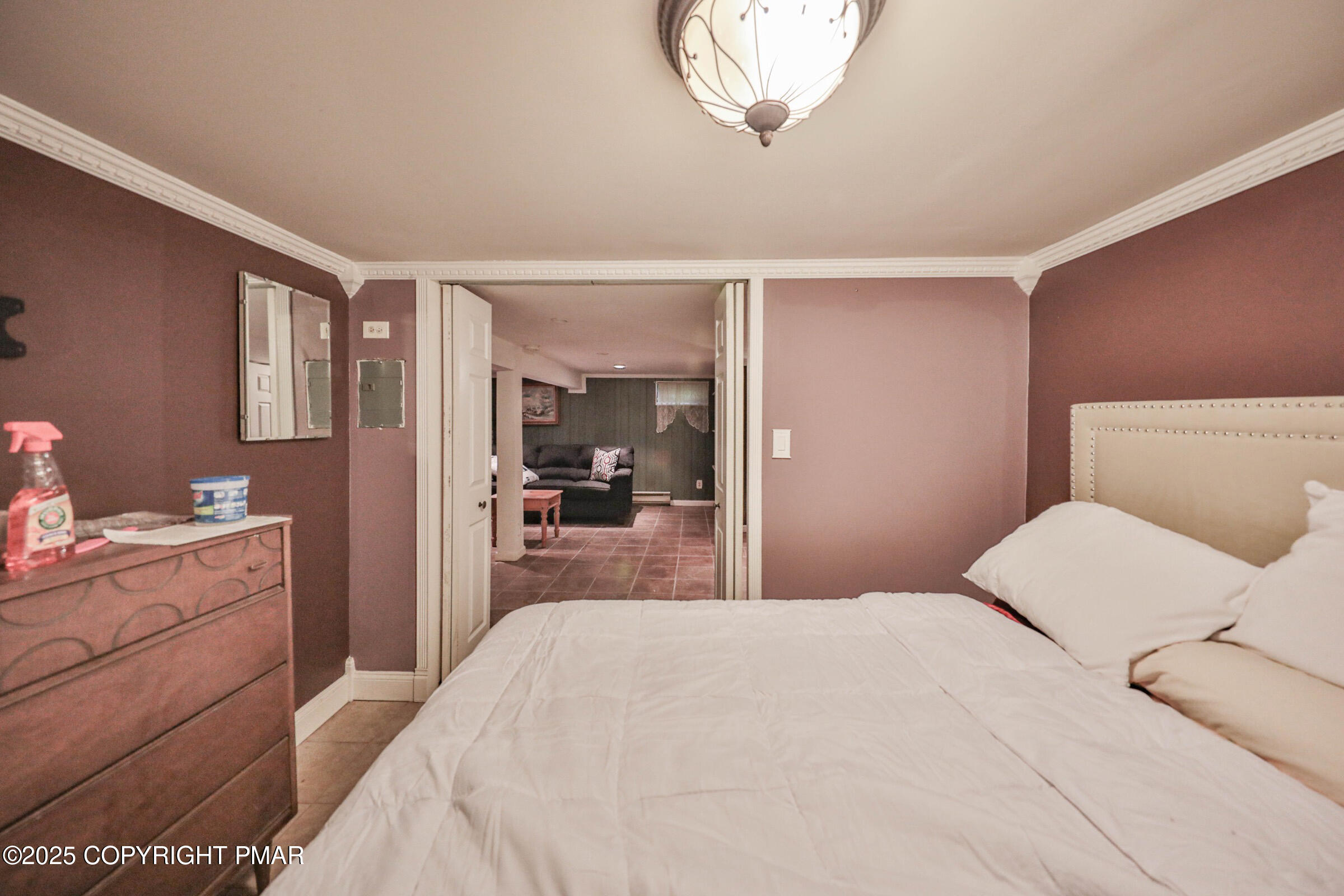 1094 Maple Lake Drive Bushkill, PA 18324 - Photo 61 of 81 a bedroom with a large bed and a chandelier