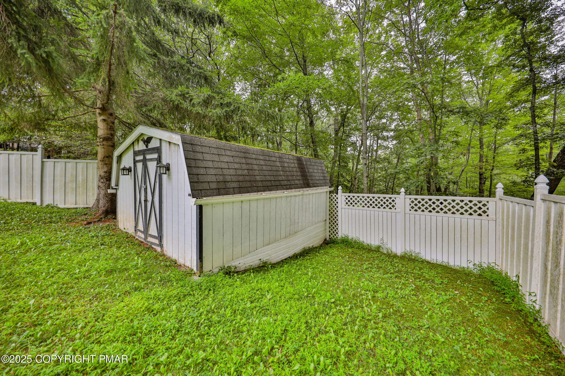 1094 Maple Lake Drive Bushkill, PA 18324 - Photo 72 of 81 a view of a backyard with white fence and a large tree