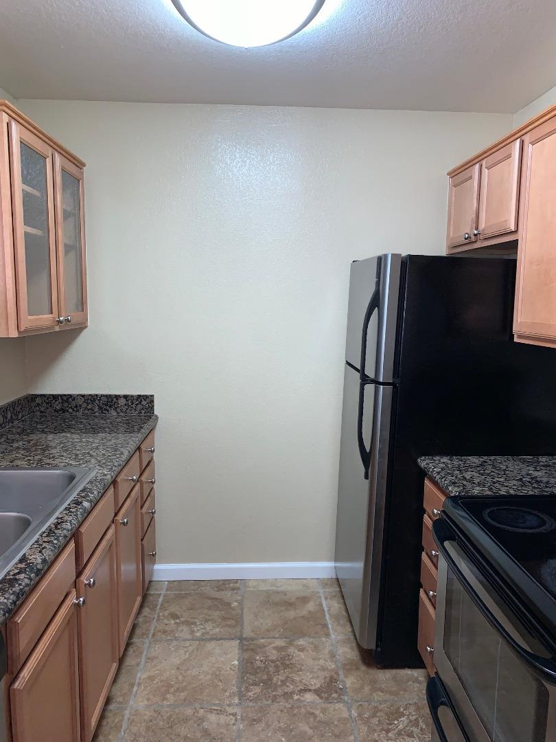 105 Reflections Drive, Unit 15 San Ramon, CA 94583 - Photo 22 of 42 a kitchen with granite countertop a refrigerator and a stove top oven