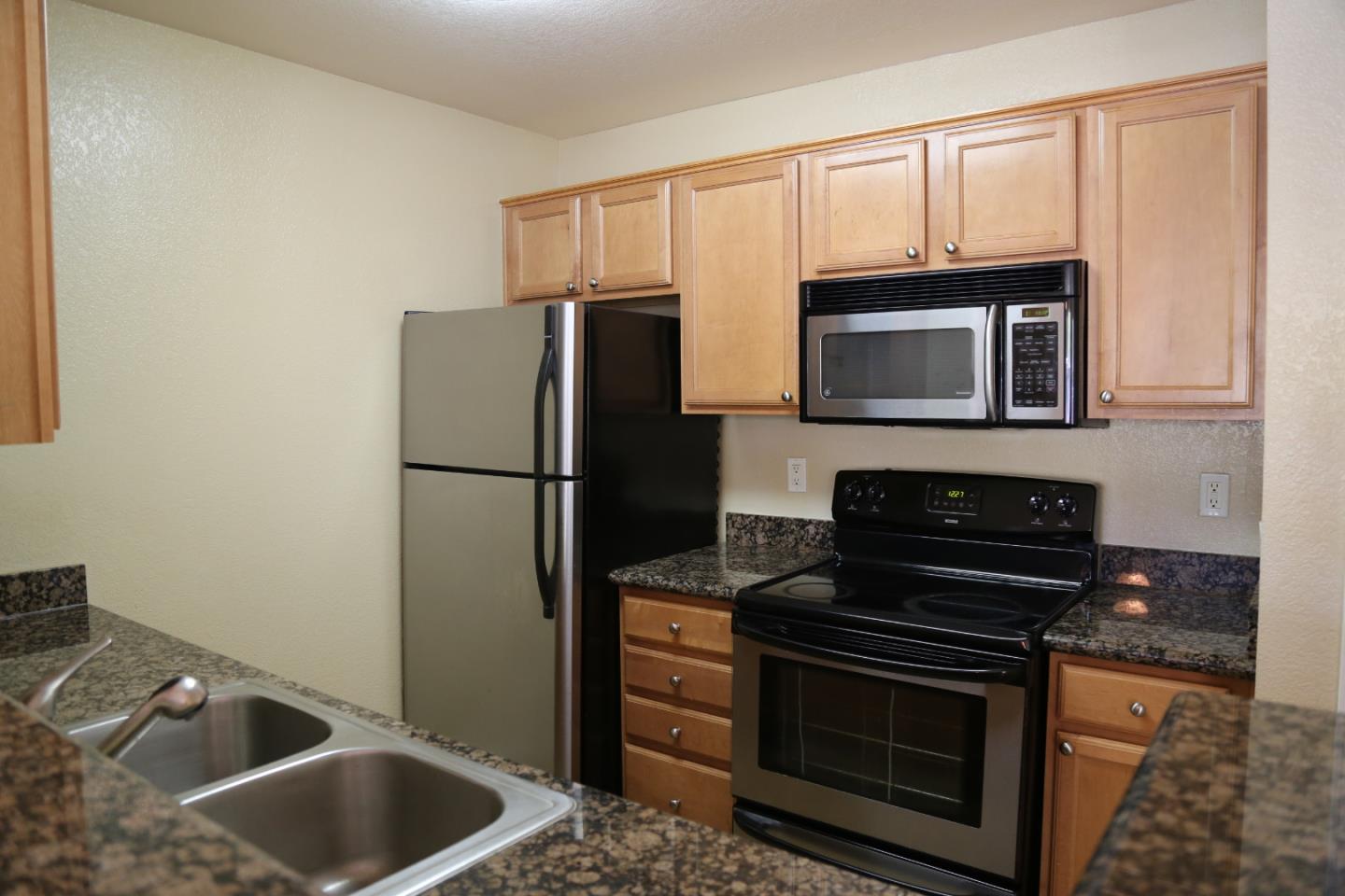 105 Reflections Drive, Unit 15 San Ramon, CA 94583 - Photo 23 of 42 a kitchen with granite countertop a sink stove and refrigerator