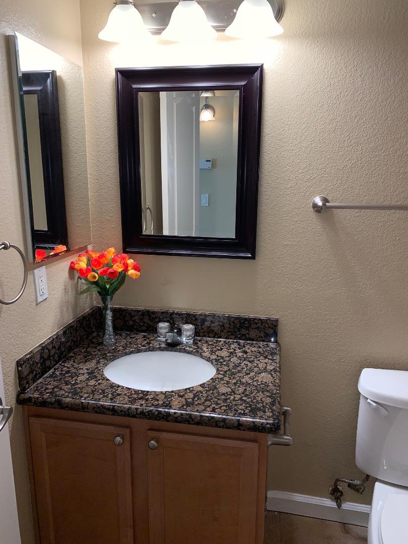 105 Reflections Drive, Unit 15 San Ramon, CA 94583 - Photo 26 of 42 a bathroom with a granite countertop sink and a mirror