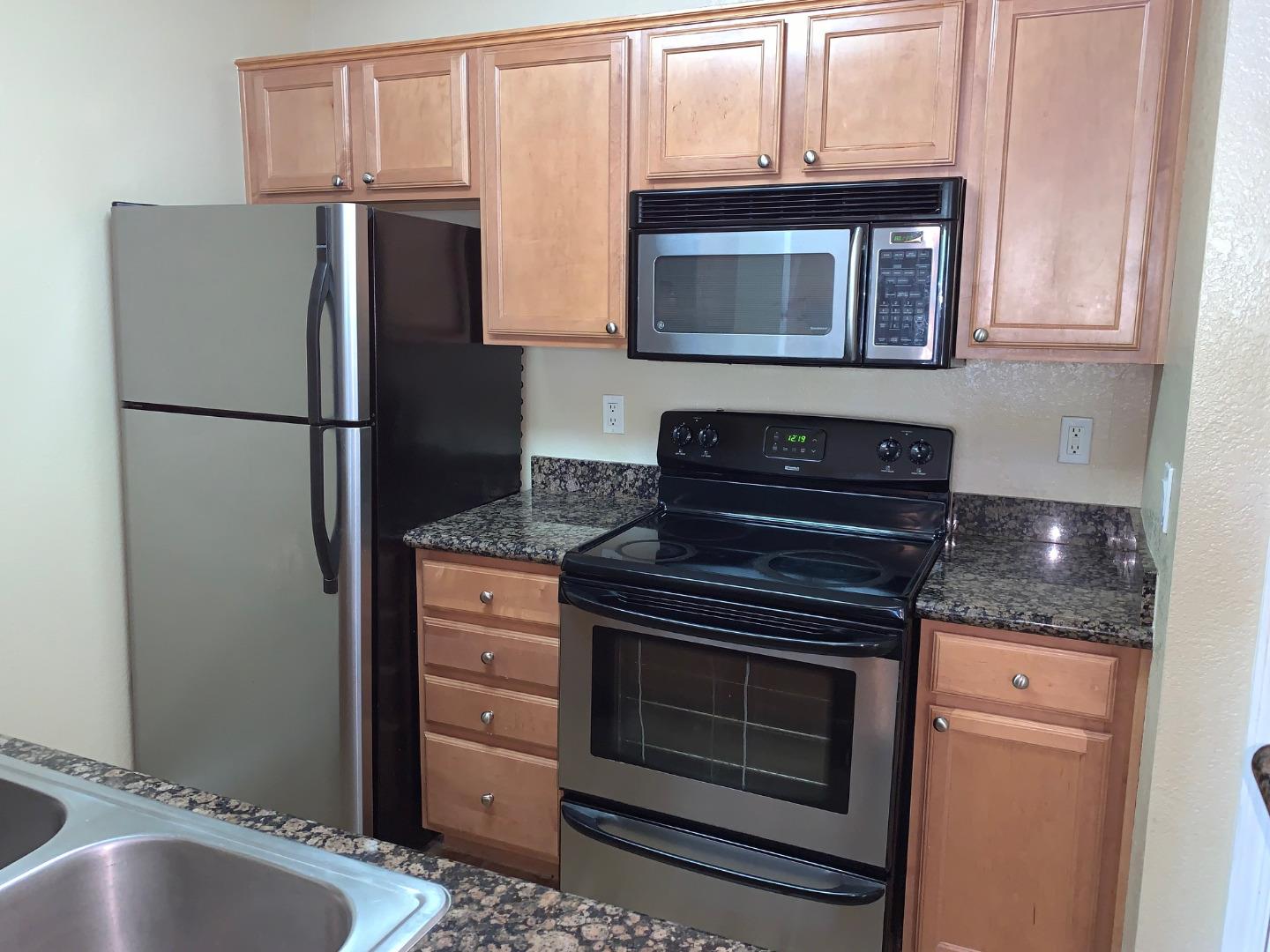 105 Reflections Drive, Unit 15 San Ramon, CA 94583 - Photo 4 of 42 a kitchen with granite countertop a refrigerator stove and microwave