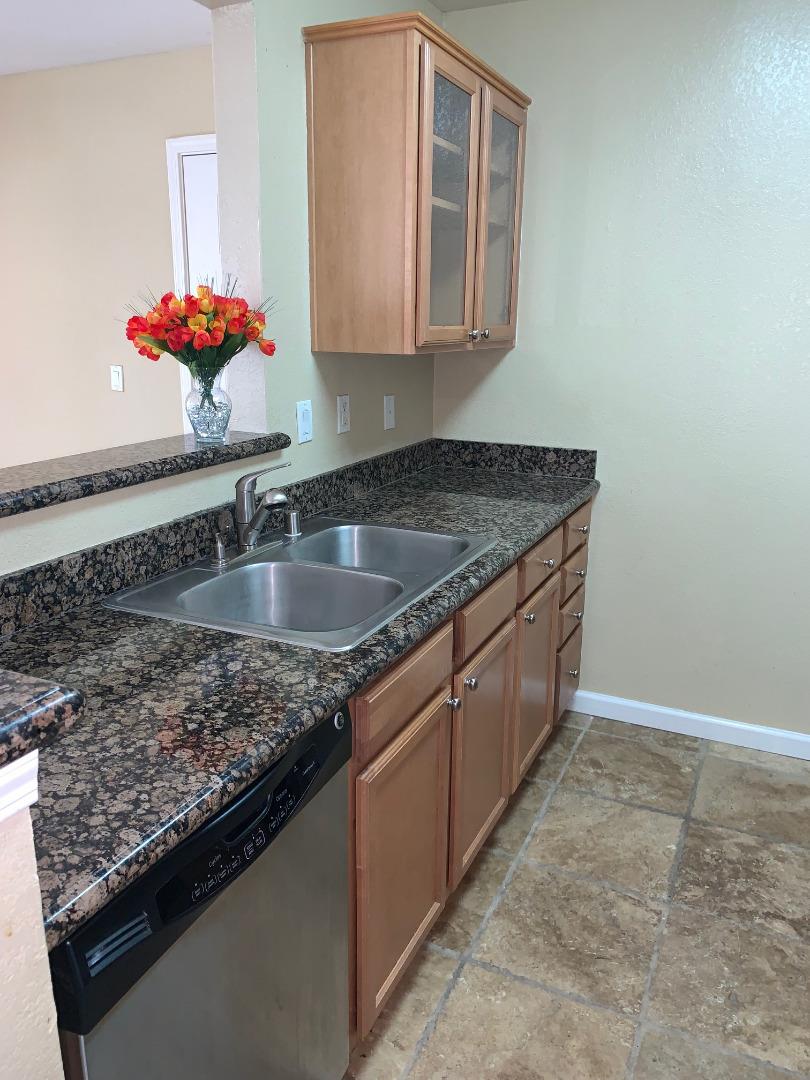 105 Reflections Drive, Unit 15 San Ramon, CA 94583 - Photo 5 of 42 a kitchen with a granite countertop sink a stove and a granite counter top
