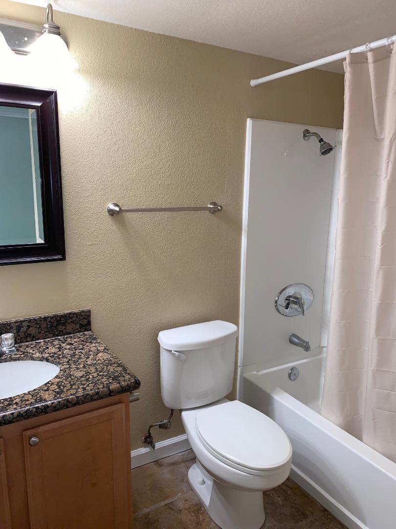 105 Reflections Drive, Unit 15 San Ramon, CA 94583 - Photo 7 of 42 a bathroom with a granite countertop toilet sink and shower