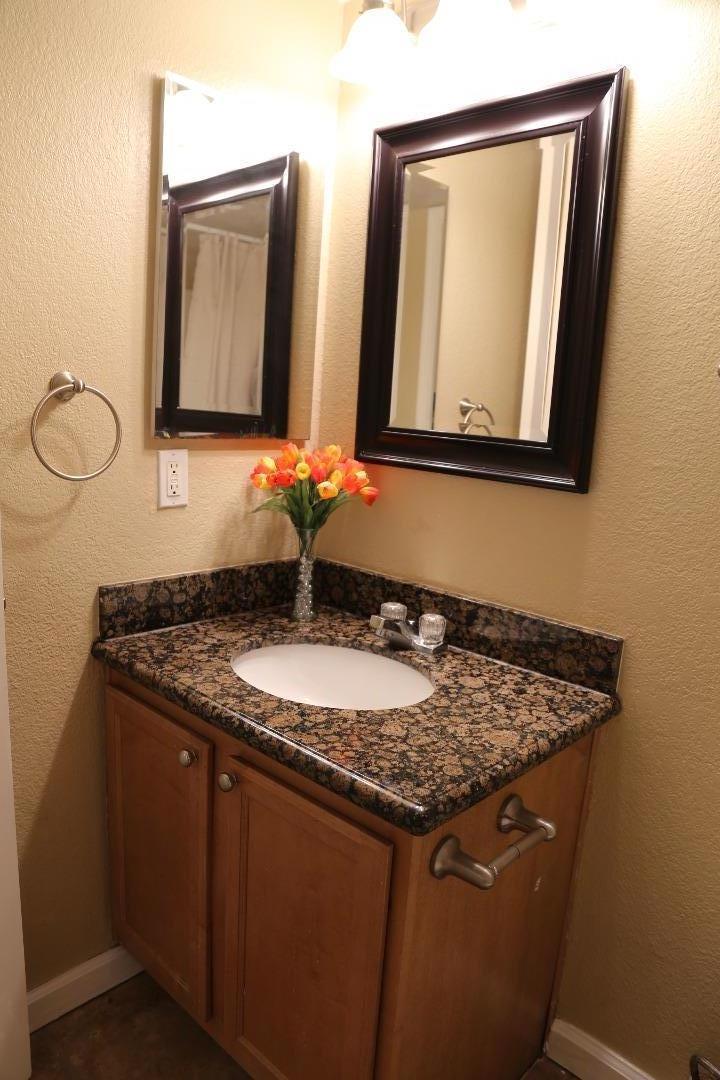 105 Reflections Drive, Unit 15 San Ramon, CA 94583 - Photo 8 of 42 a bathroom with a granite countertop sink and a mirror