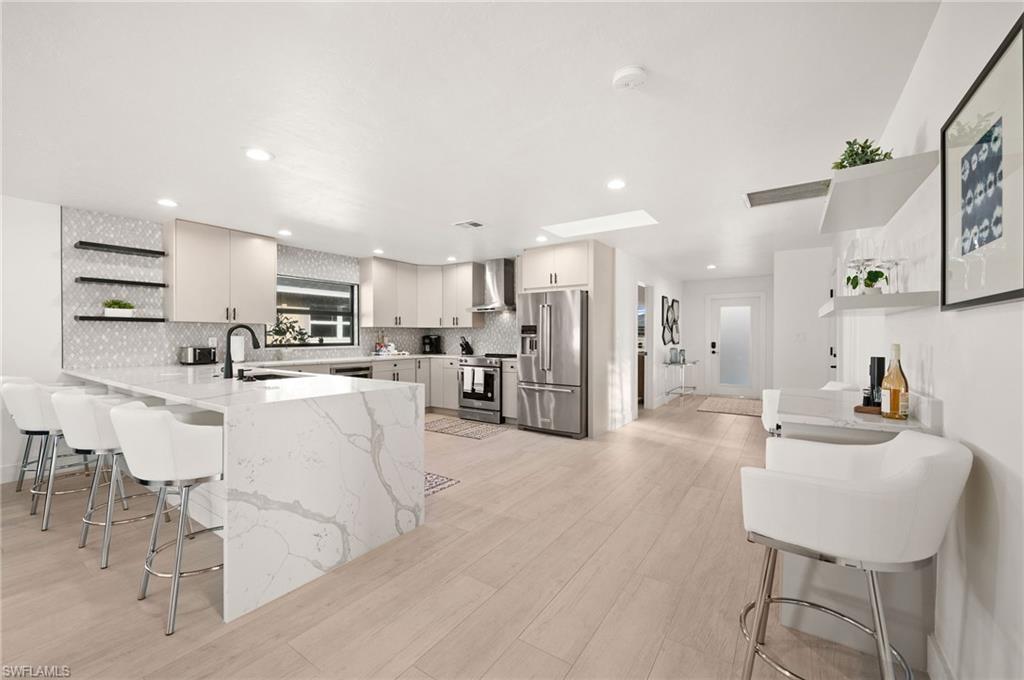 a living room with stainless steel appliances kitchen island furniture and a view of kitchen