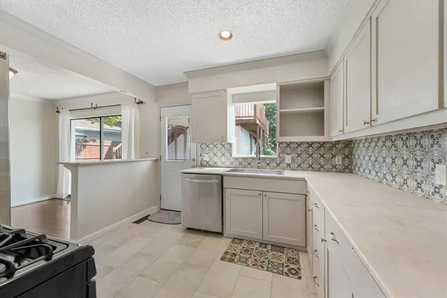 a kitchen with granite countertop a sink stove and cabinets