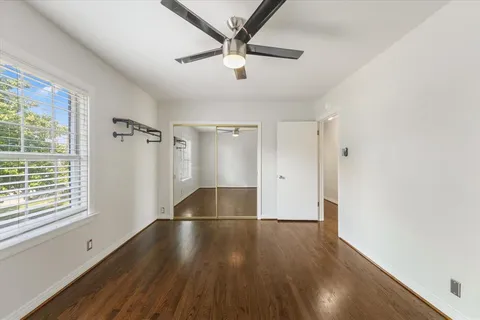 a view of a livingroom with wooden floor and a ceiling fan
