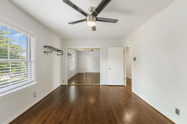 a view of a livingroom with wooden floor and a ceiling fan