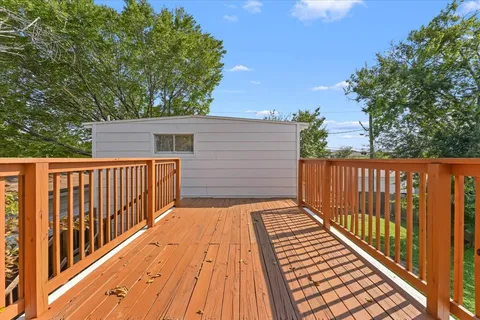 a view of backyard with wooden floor and fence