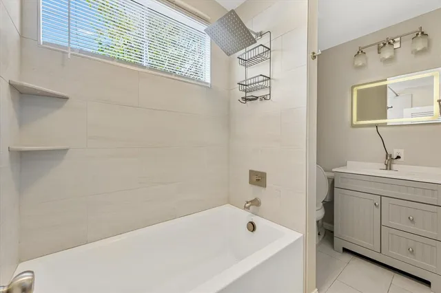 a bathroom with a tub a sink and mirror