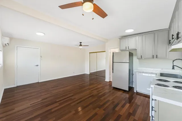 a view of a kitchen with a refrigerator a ceiling fan and wooden floor