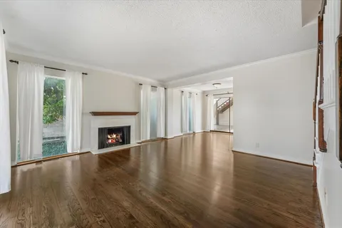 a view of empty room with wooden floor and fireplace