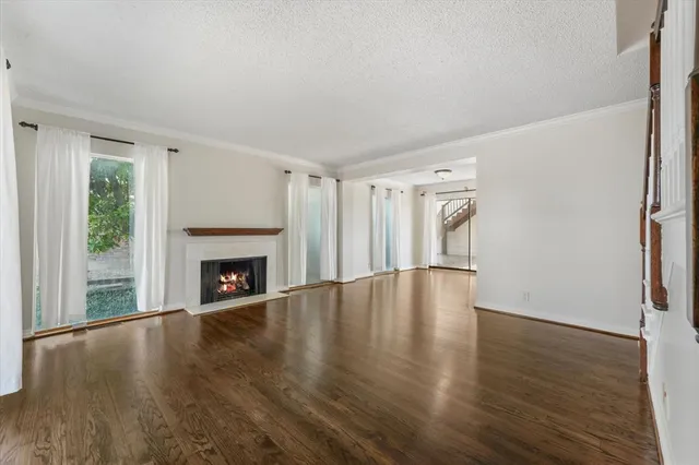 a view of empty room with wooden floor and fireplace