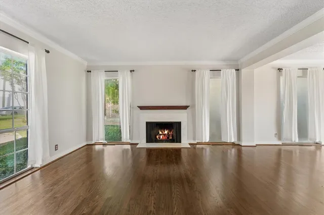 a view of wooden floor fire place and windows in a room