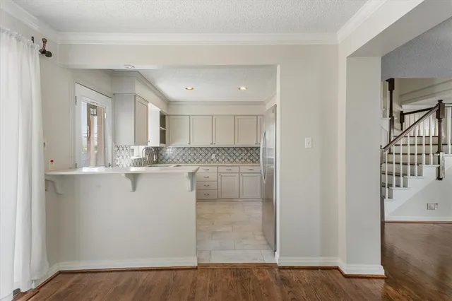 a view of a kitchen with white cabinets and wooden floor