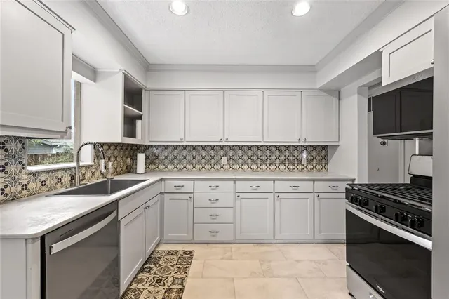 a kitchen with granite countertop cabinets stainless steel appliances and a sink