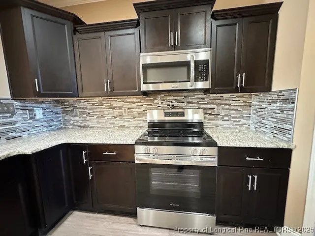 a kitchen with granite countertop a stove sink and microwave