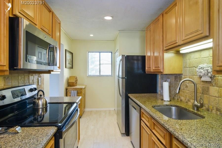 5353 Southeast Miles Grant Road, Unit F206 Stuart, FL 34997 - Photo 14 of 39 Kitchen has granite counters, with pass through to dining area.