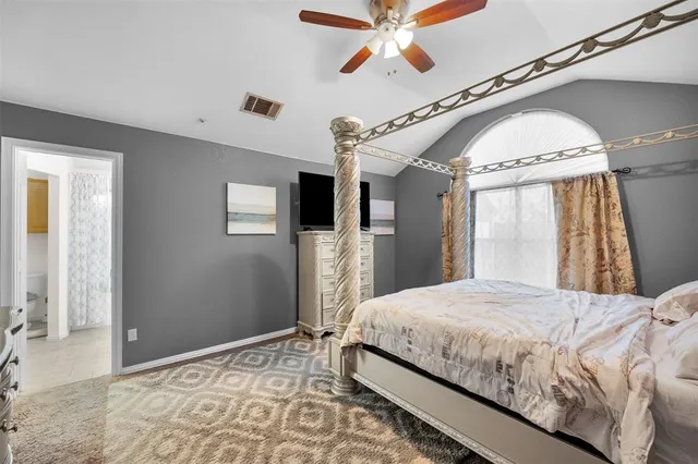a bedroom with a large bed and a chandelier