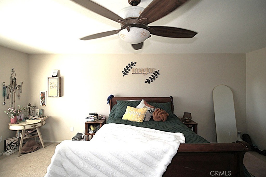 924 Condor Street Barstow, CA 92311 - Photo 31 of 52 a bedroom with a bed and a chandelier