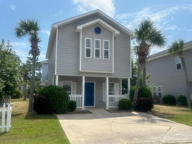 a front view of a house with a yard and potted plants