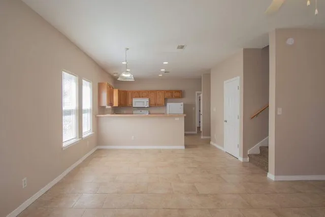 a view of a kitchen with a refrigerator and white cabinets