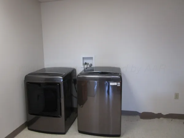 a utility room with wooden floor washer and dryer