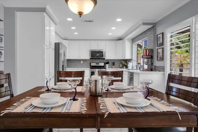 a room with table chairs and a chandelier
