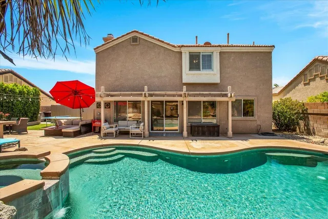 a view of a swimming pool with a bench and trees around