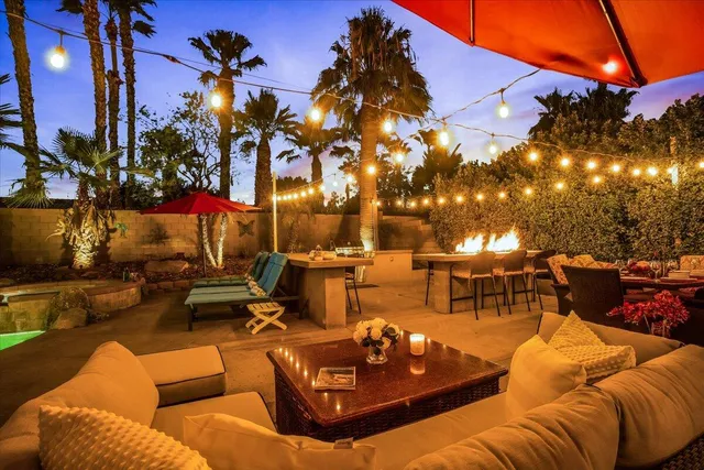a view of a patio with couches table and chairs and potted plants