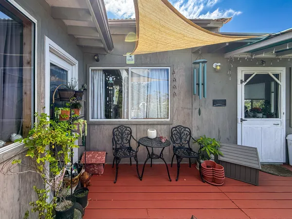 a view of a porch with chairs and potted plants
