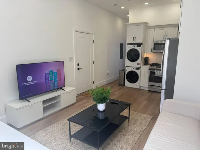 a living room with furniture and a view of kitchen