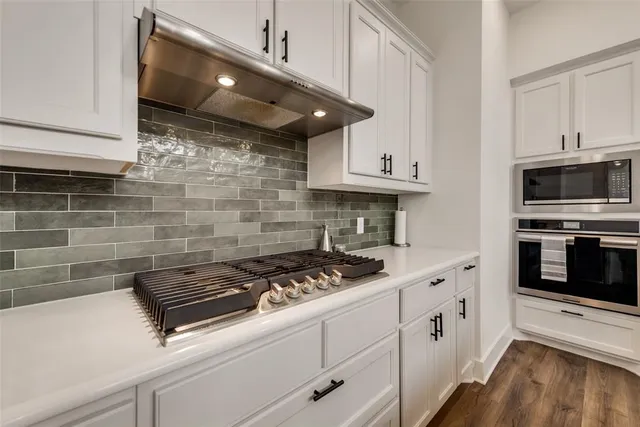 a kitchen with stainless steel appliances granite countertop a sink stove and microwave