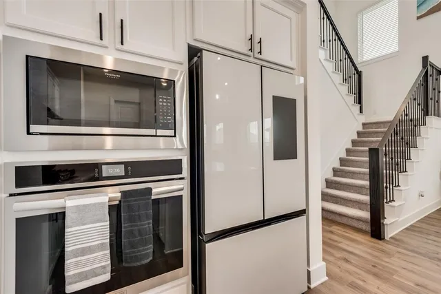 a kitchen with granite countertop white cabinets and white appliances