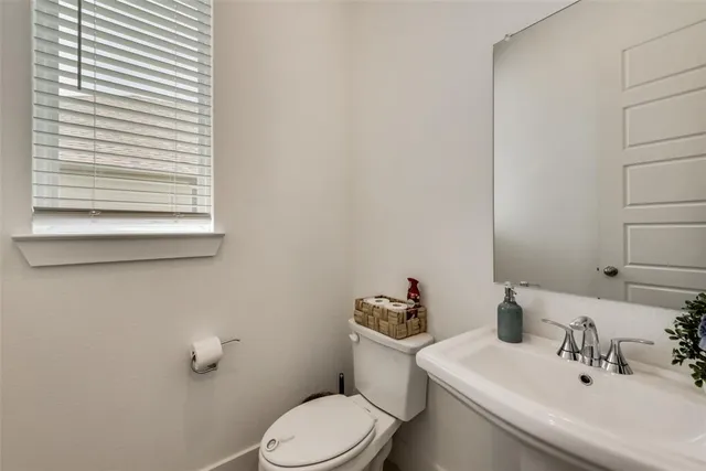 a bathroom with a toilet a sink and mirror