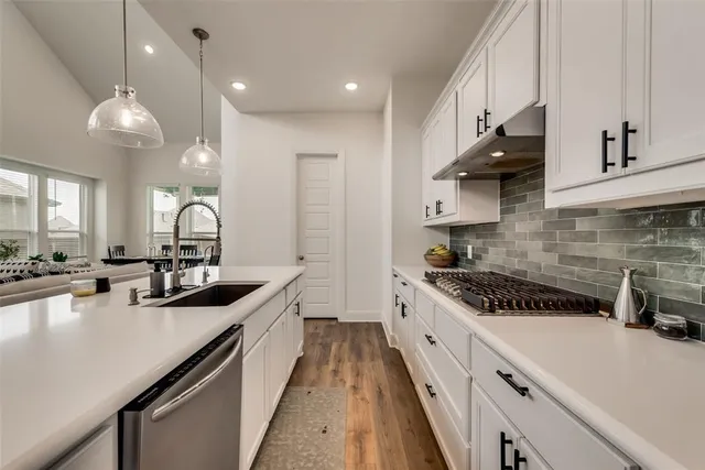 a kitchen with a sink a stove and cabinets
