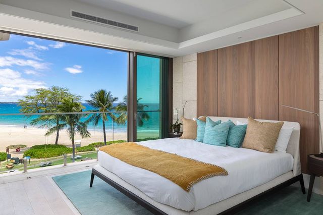 a bed sitting in a bedroom next to a window and palm tree