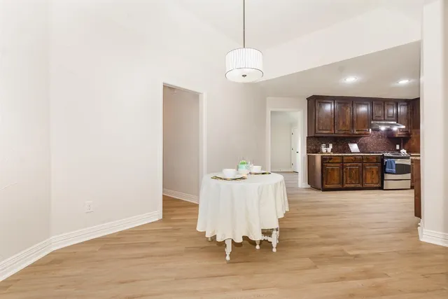 a kitchen with stainless steel appliances granite countertop a refrigerator a sink a stove and oven with wooden floor