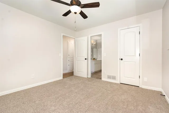 an empty room with chandelier fan