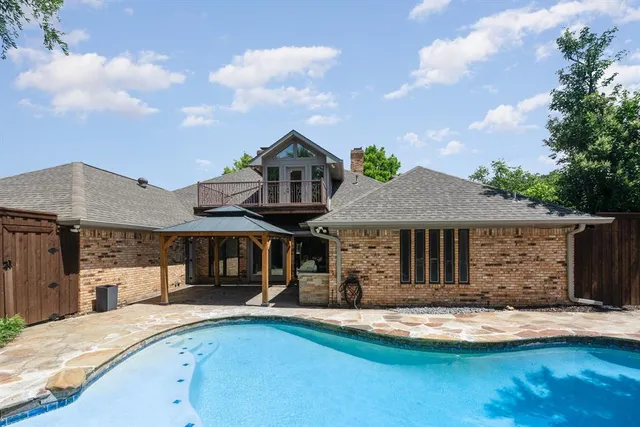 a front view of a house with swimming pool having outdoor seating