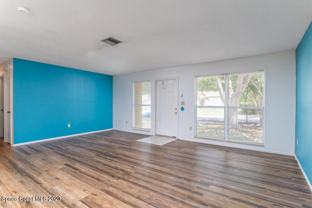 1330 Creel Road Northeast Palm Bay, FL 32905 - Photo 4 of 37 a view of an empty room with wooden floor and a window
