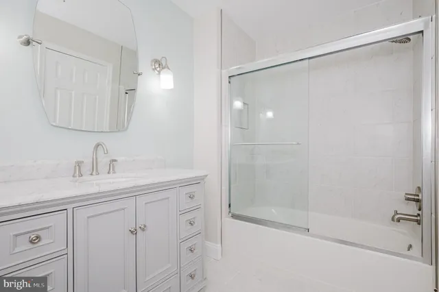 a bathroom with a shower sink and mirror