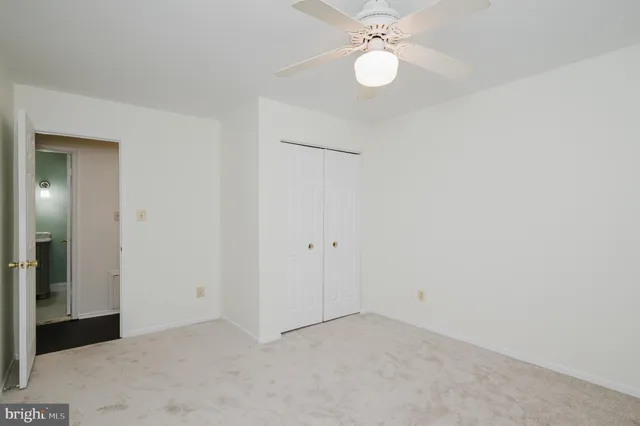 an empty room with a fan and a chandelier fan