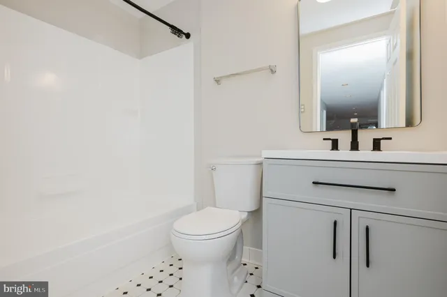 a bathroom with a sink toilet vanity and shower