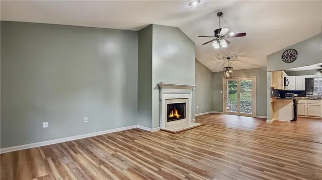 a view of empty room with wooden floor and fireplace